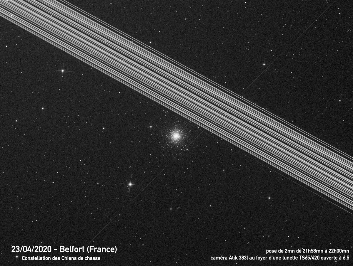 Image spectaculaire de l’amas globulaire M3 prise le 23 avril 2020, barrée par le passage d’une armada de 60 satellites Starlink qui viennent laisser une épaisse traînée lumineuse